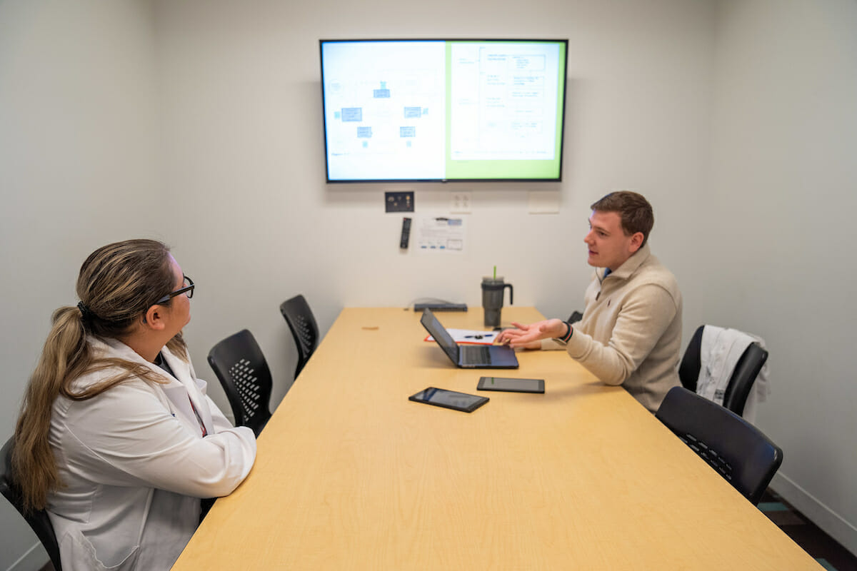 Two students in study room with monitor