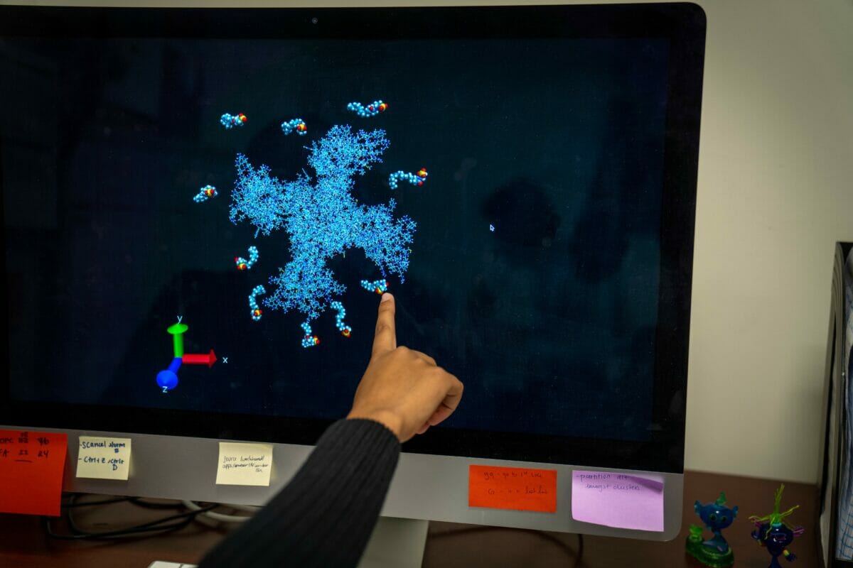 a person pointing at a computer screen with a snowflake on it.