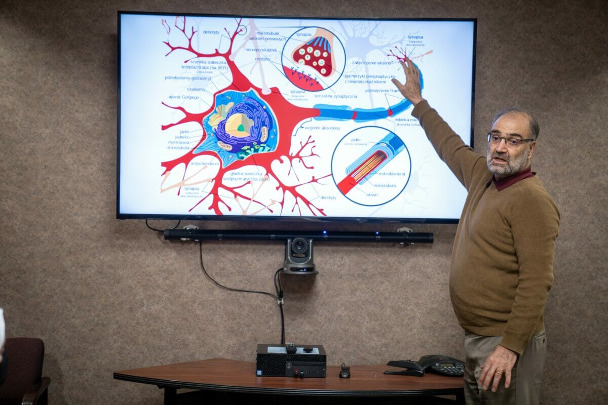 a man standing in front of a projection screen.