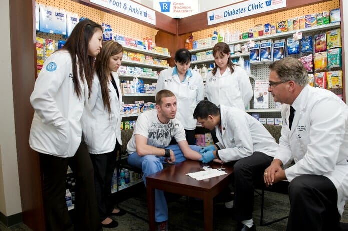 Five students, One faculty, and one patient in a pharamacy.