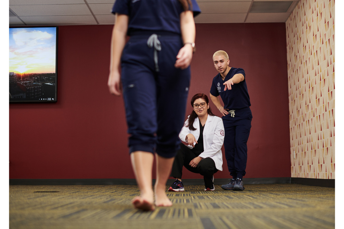 Two women in scrubs standing next to each other in an office.
