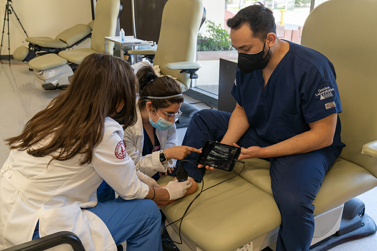 College of Podiatric Medicine Dr. Reina Deogracias and CPM students Brandon Rocha and Shylla Taqi use a portable ultrasound for marketing photos.