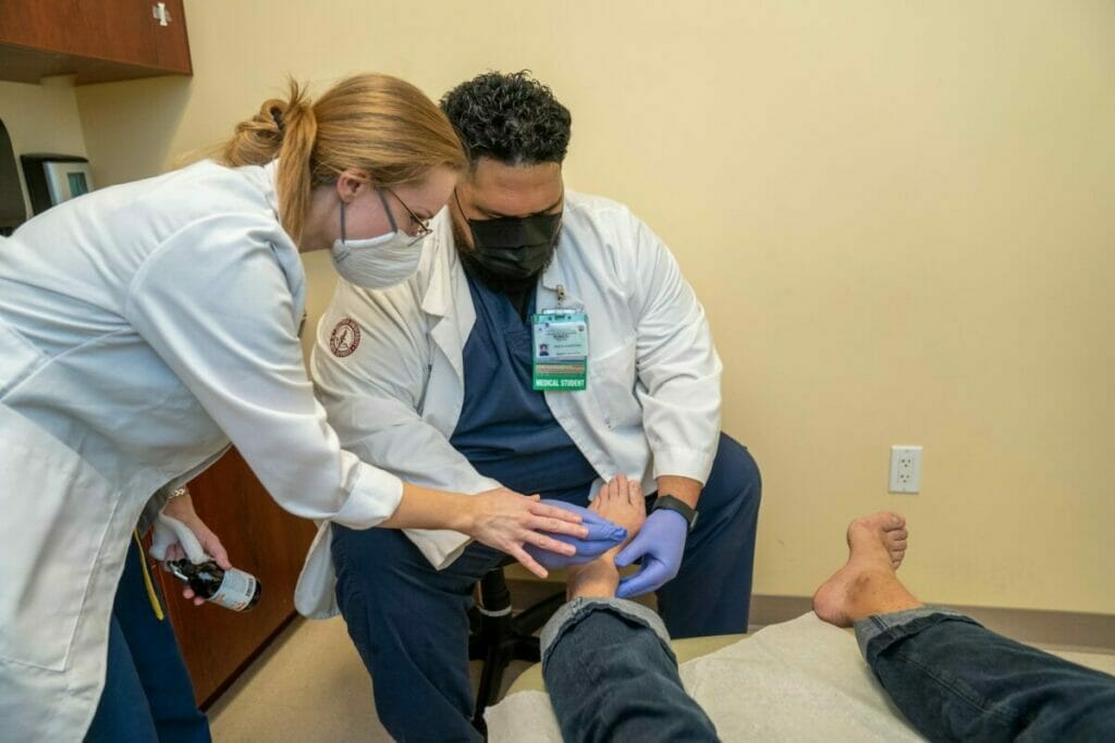 Student examining patient's foot