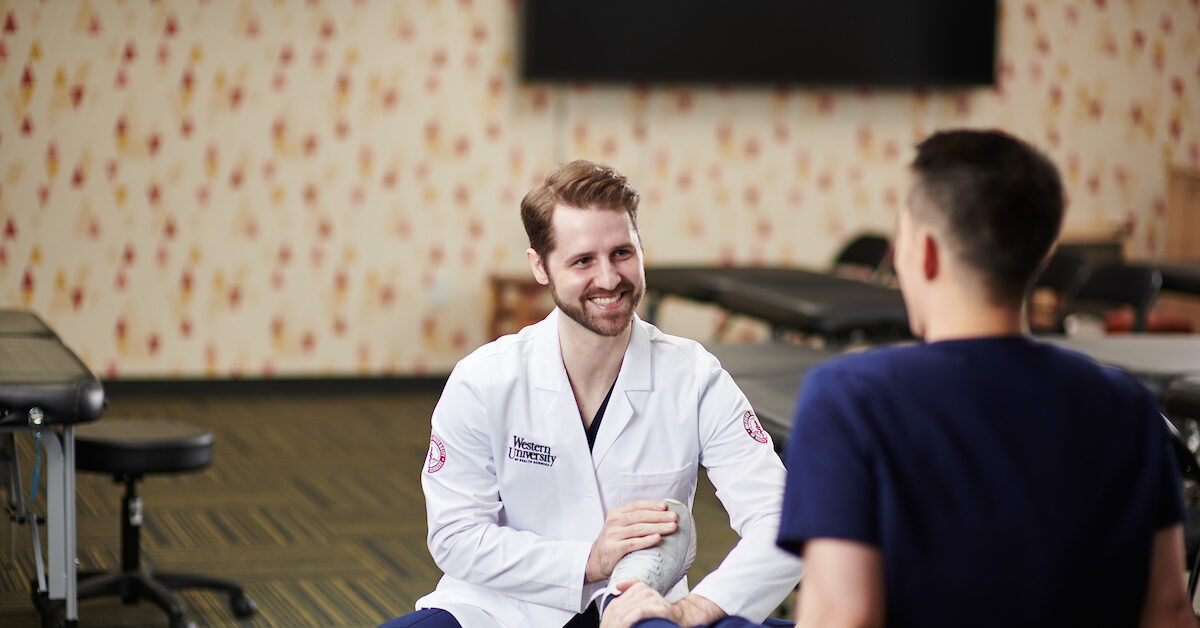 Student smiling examining foot