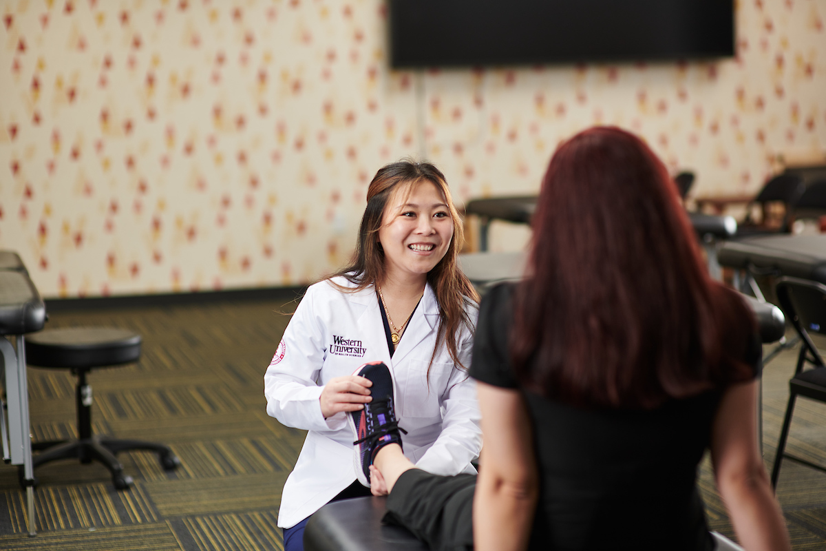 student smiling examining foot