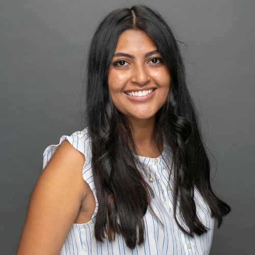 An indian woman smiling for the camera.