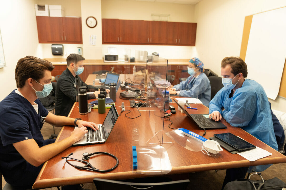 Students seated around table with laptops