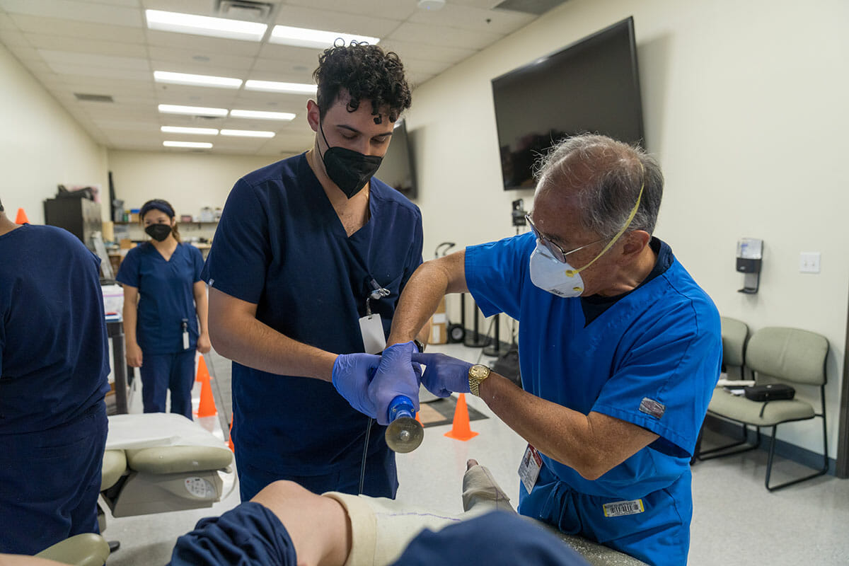 Image of a Podiatrist teaching a student in a clinic.