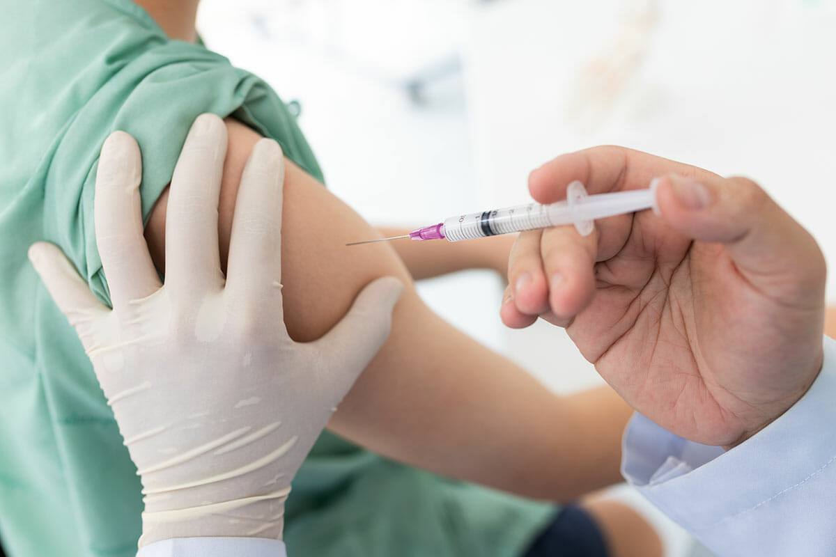 Image of a doctor giving a vaccination in the arm of a patient.