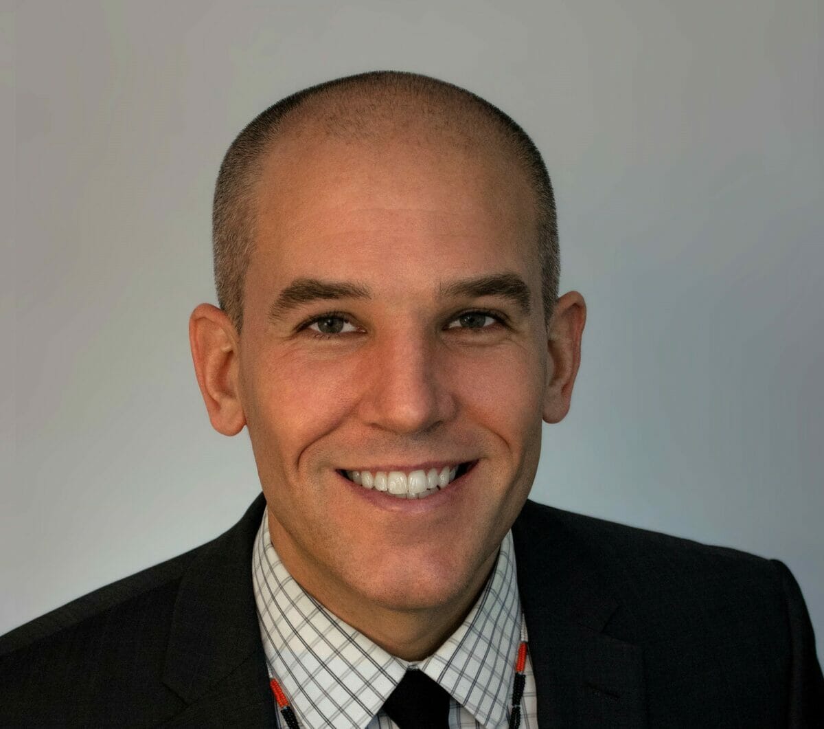 Head shot of Dr. Bradley Henson in a dark suit with light shirt and black tie
