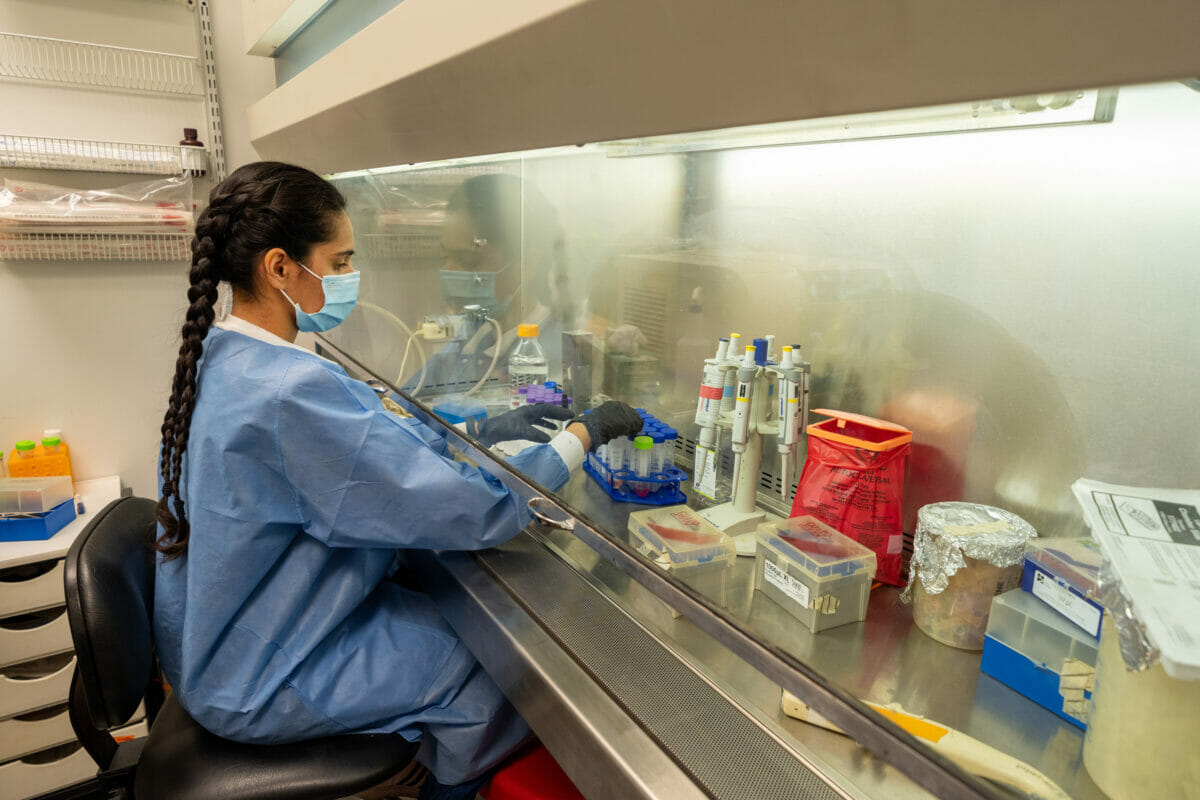 Student working at table with vials of liquid