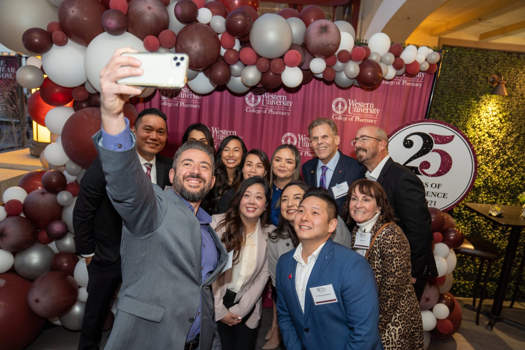 Group of people taking a selfie, smiling.