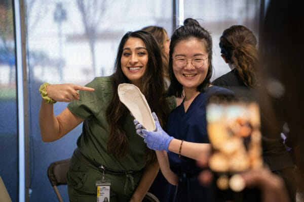 Two women in scrubs posing.