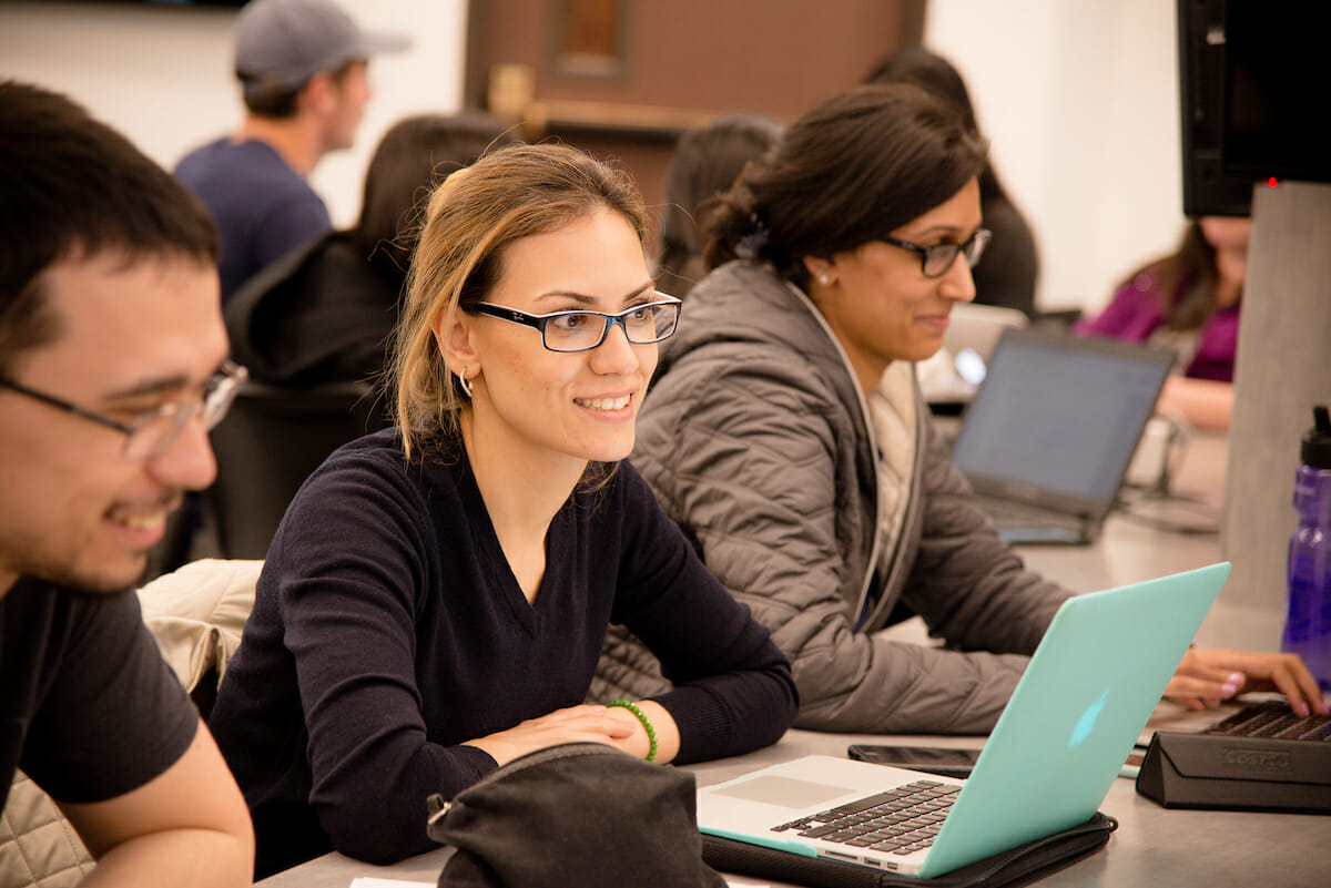 A group of people using laptops at a table.