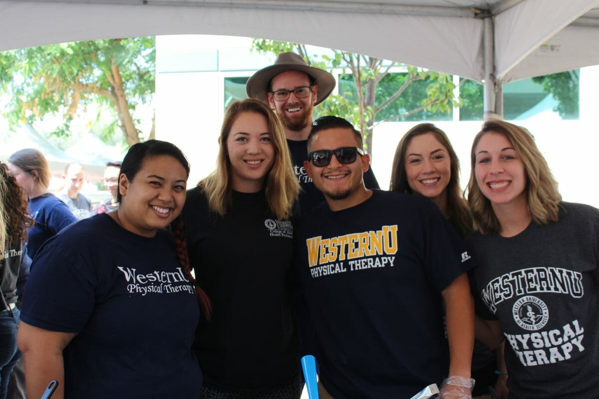 six students smiling in outside setting