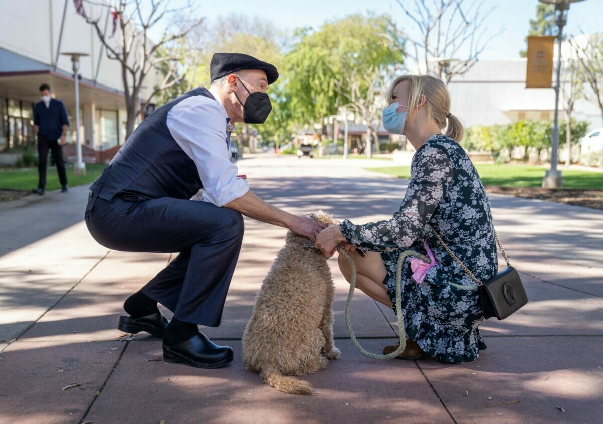 Dr. Robin Farias-Eisner speaking with woman and her pet dog