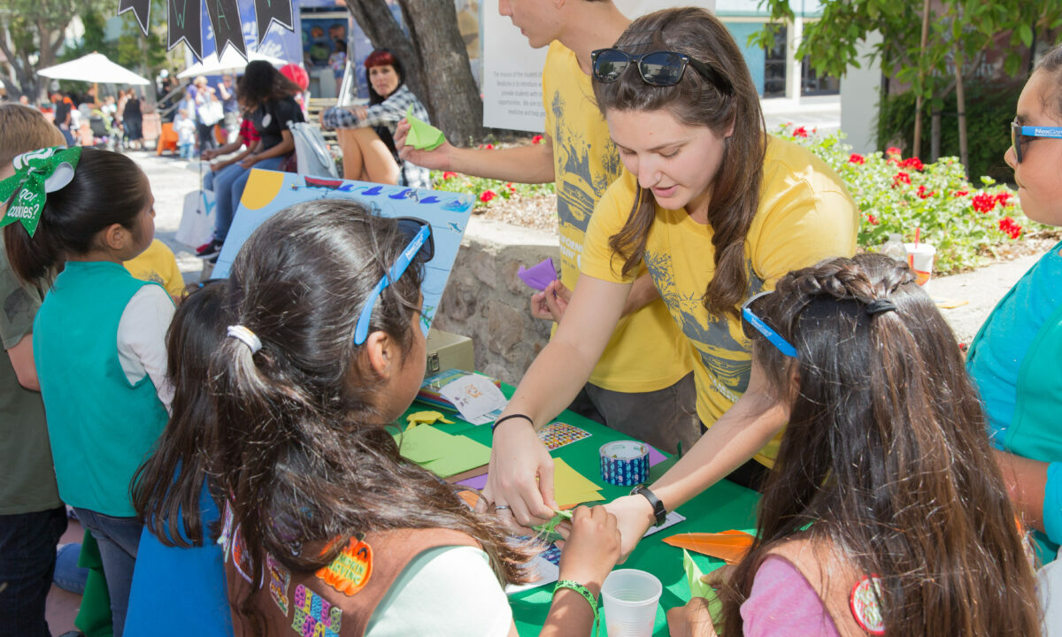 A girl scout wearing a yellow shirt.