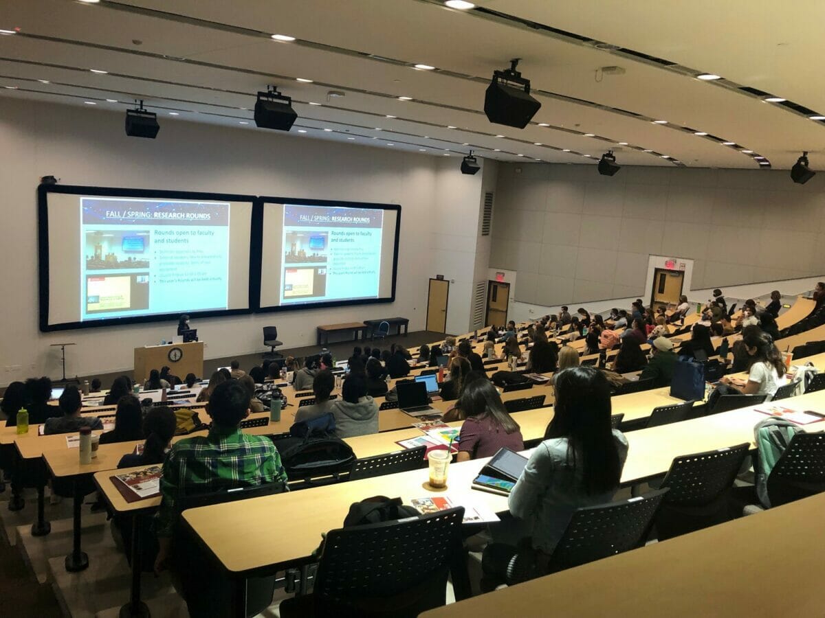 Students in lecture hall viewing slides on a screen