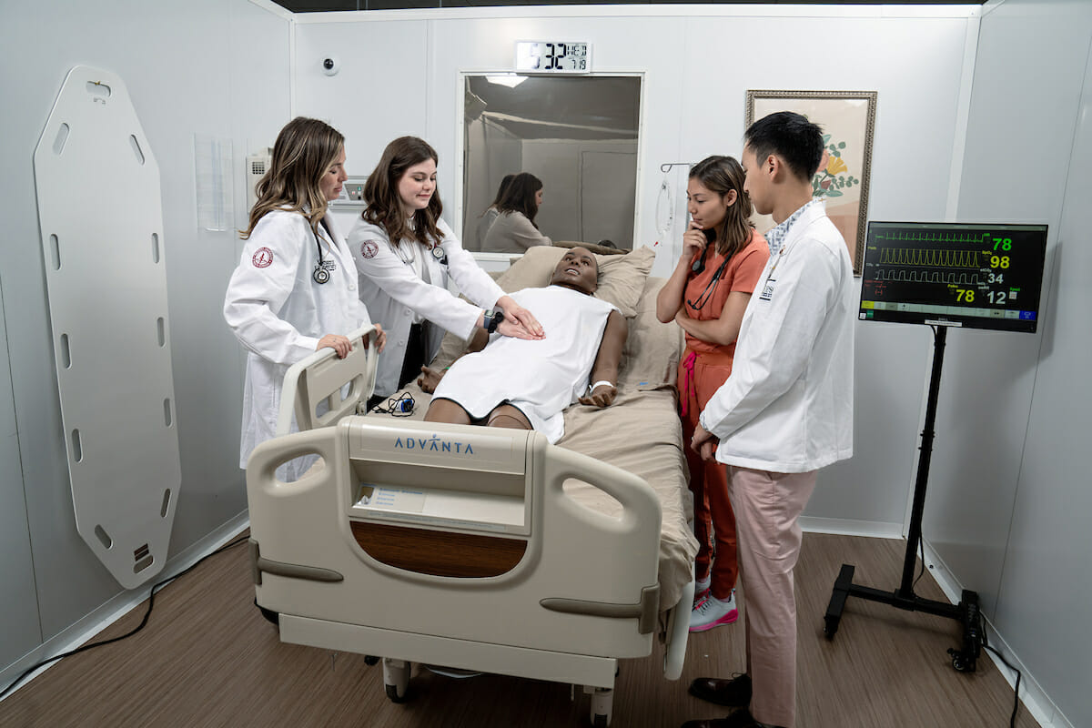 Faculty and three students with patient mannequin.