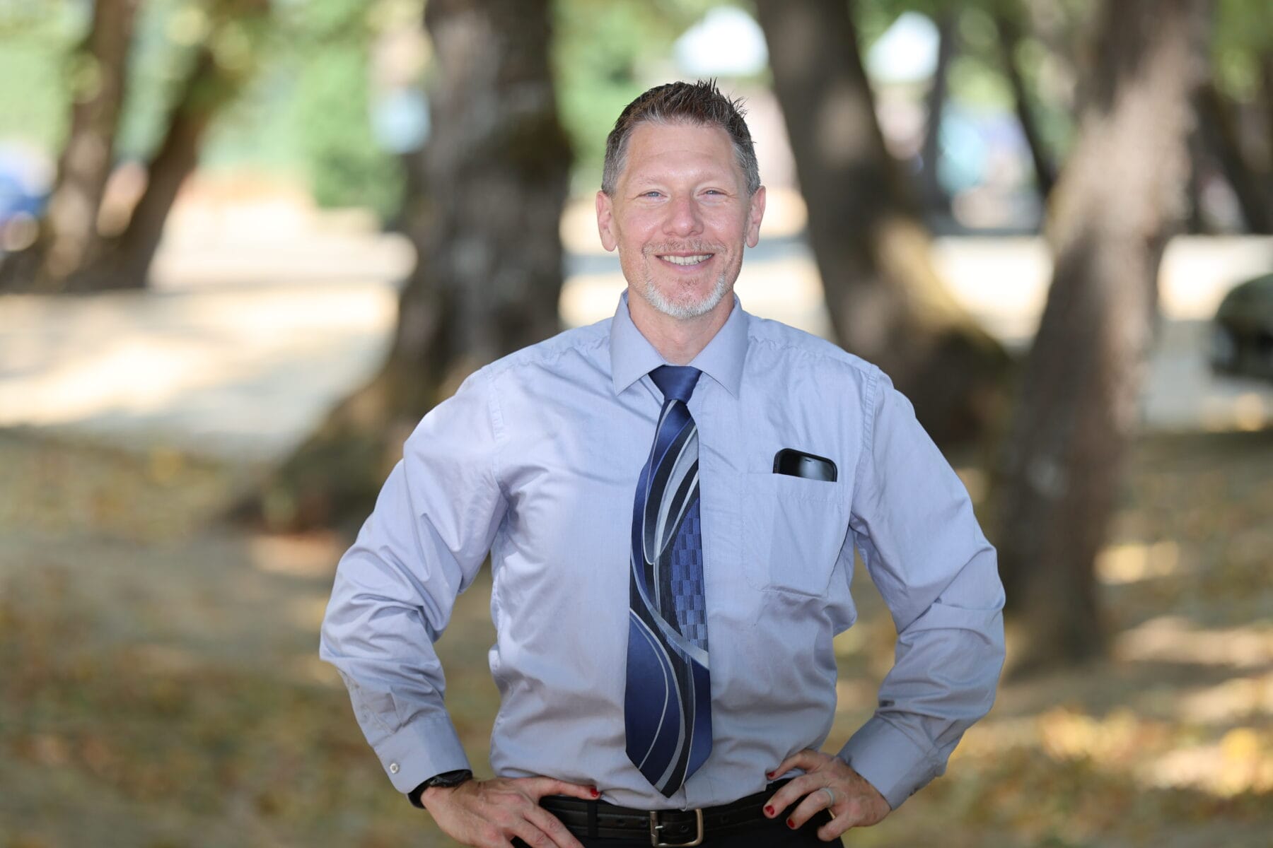 Man standing with hands on waist.