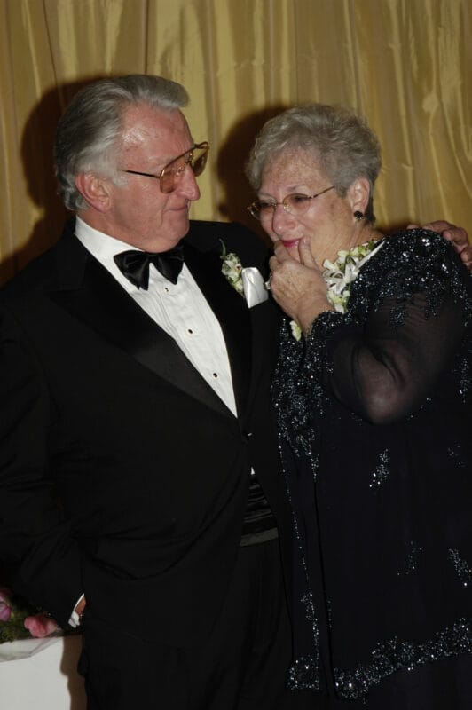 Man and woman in formal dress attire hugging