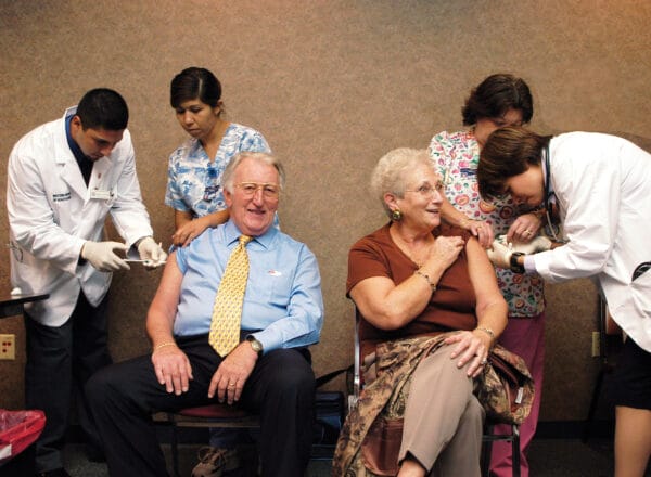Older man and woman receiving a flu shot.