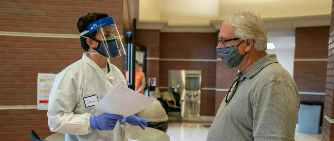 WesternU has been designated a Los Angeles County community health care partner providing COVID-19 vaccines. Faculty, students and staff work and volunteer at the vaccine site, providing a unique interdisciplinary approach Thursday February 18, 2021. Patient Jim Metcalf of Santa Clarita goes through some pre-test questions with Chris XXXX. (Jeff Malet, WesternU) *Signed image release form from patient