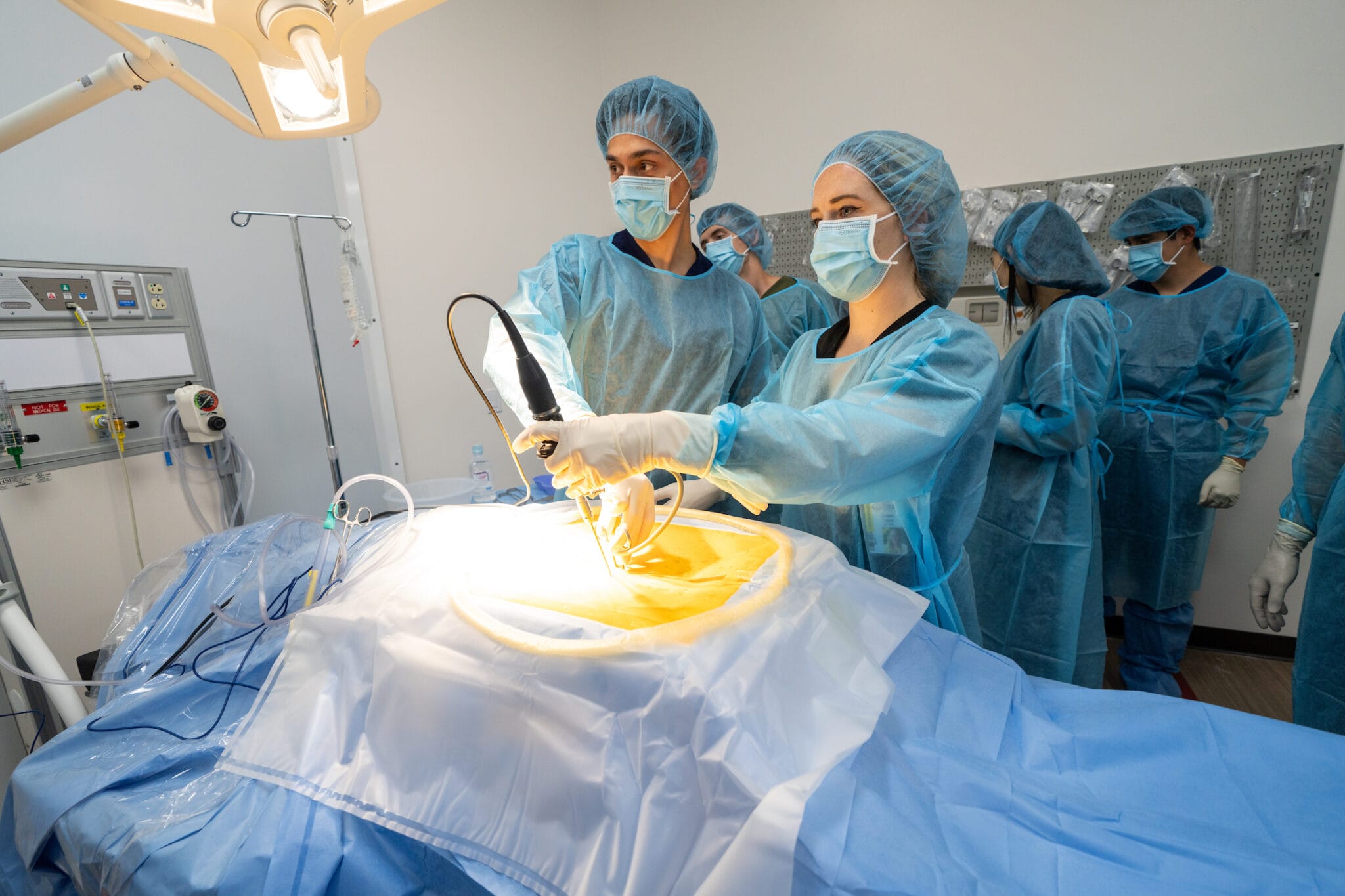 Male and femlate doctor inserting a medical instrument into a mannequin