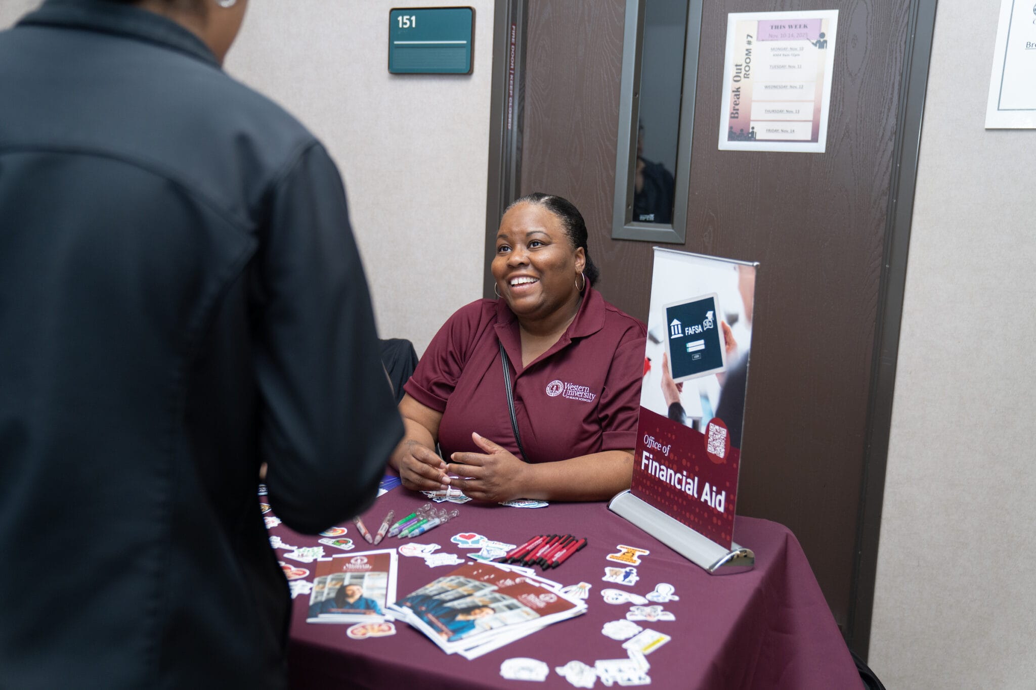 woman sitting at table, financial aid sign