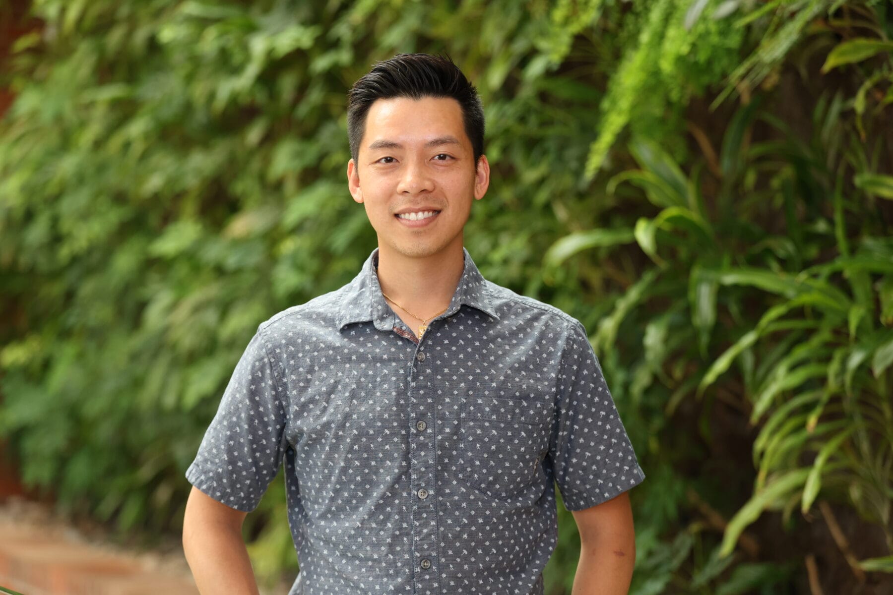 Asian man standing, smiling