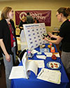 Food Day Event Picture of a staff member with a woman near a table with food items