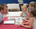 No Limits fundraiser young children from the Lebanon Community School District at a table with a medical student speaking about the event
