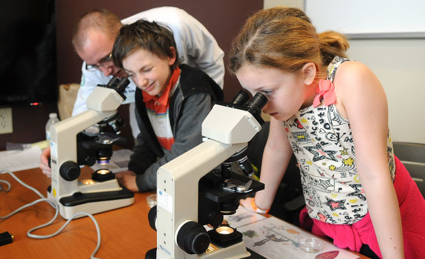 viewing parasites picture of middle-school students using microscopes